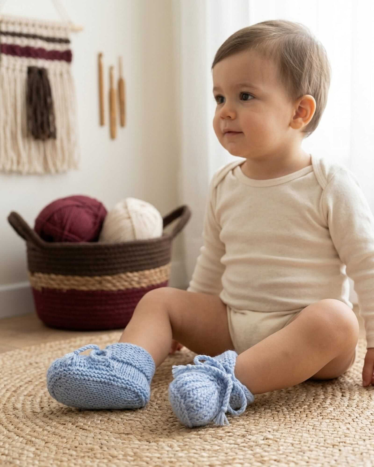 a baby wearing hand-knitted light blue baby boots made of merino